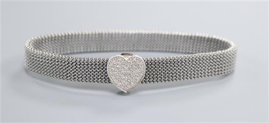 An expanding metal mesh bracelet with a 14k white metal and diamond encrusted heart shaped sliding clasp.